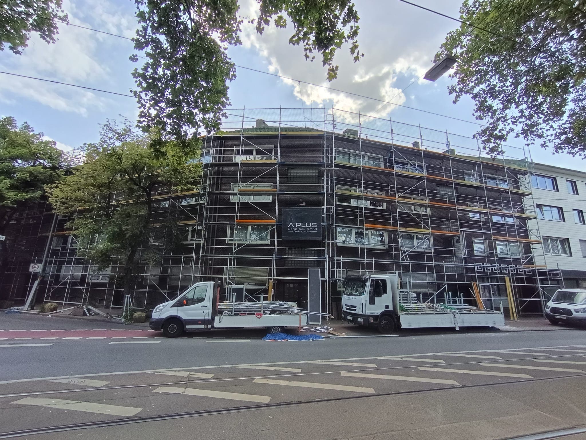 Arbeitsgerüst mit durchgehenden Ebenen und Seitenschutz an einem Mehrfamilienhaus